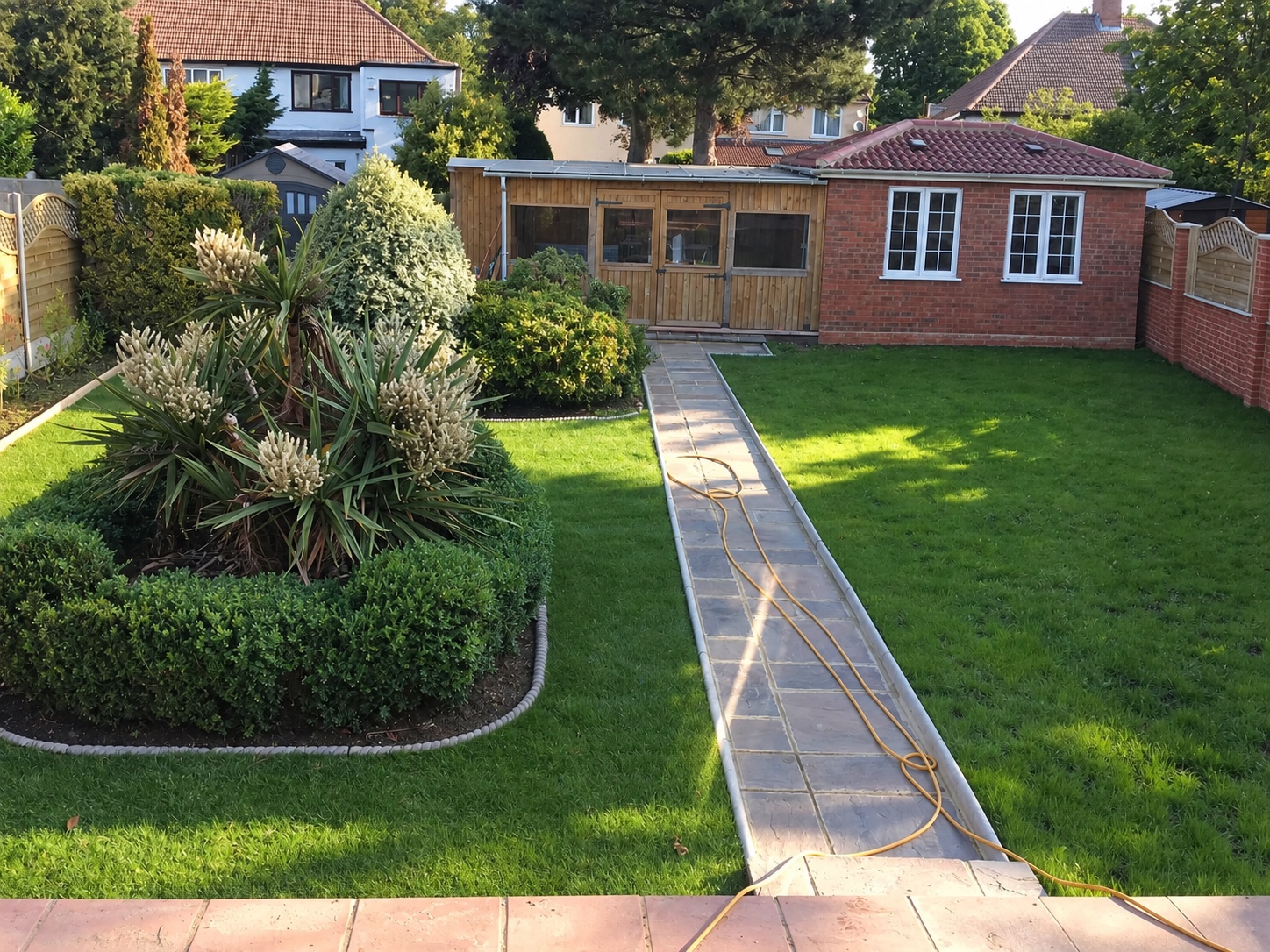 Landscaped garden with lawns, planted borders and a central stone path