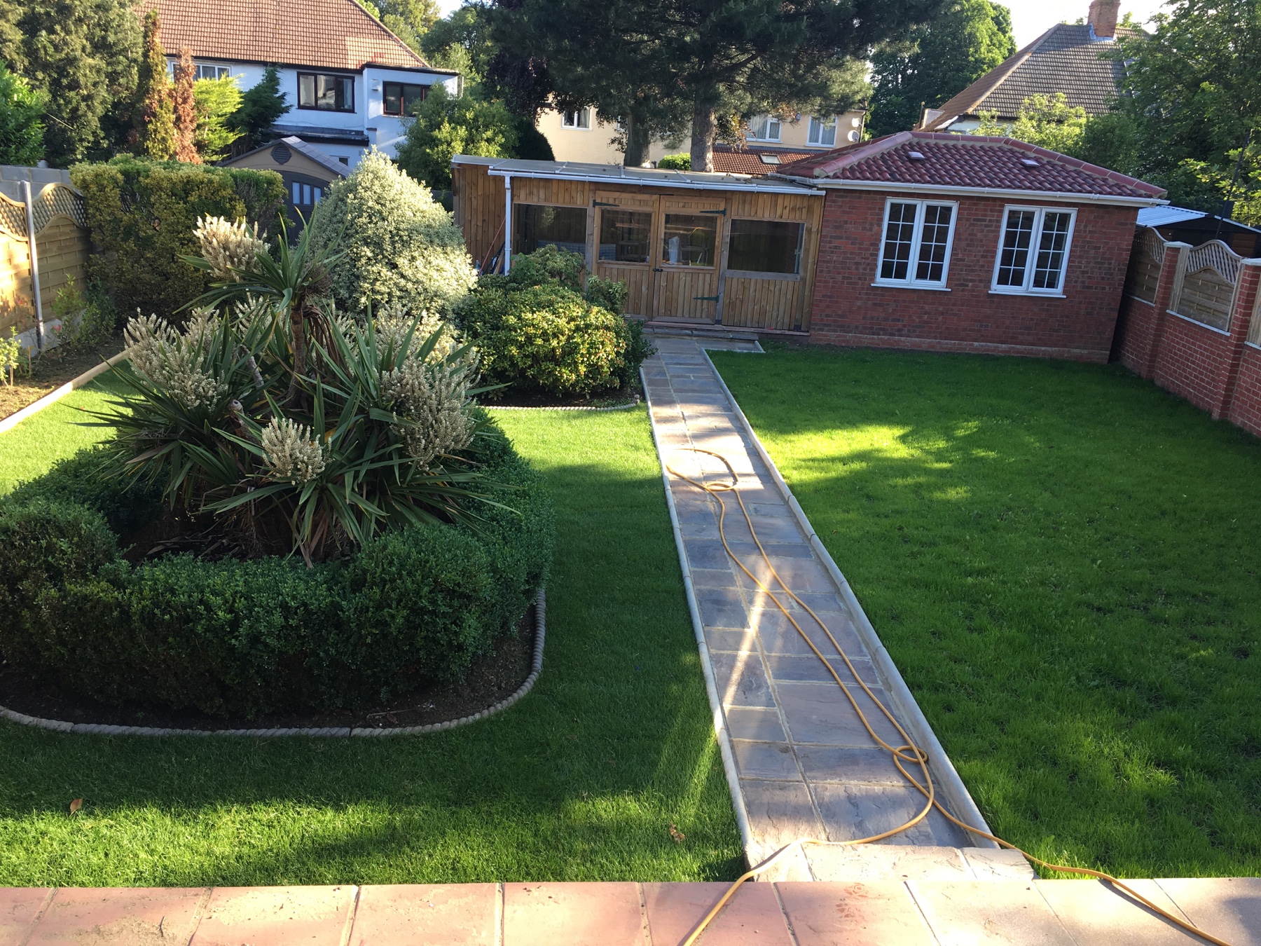 The same garden after landscaping with refreshed lawns and a central path